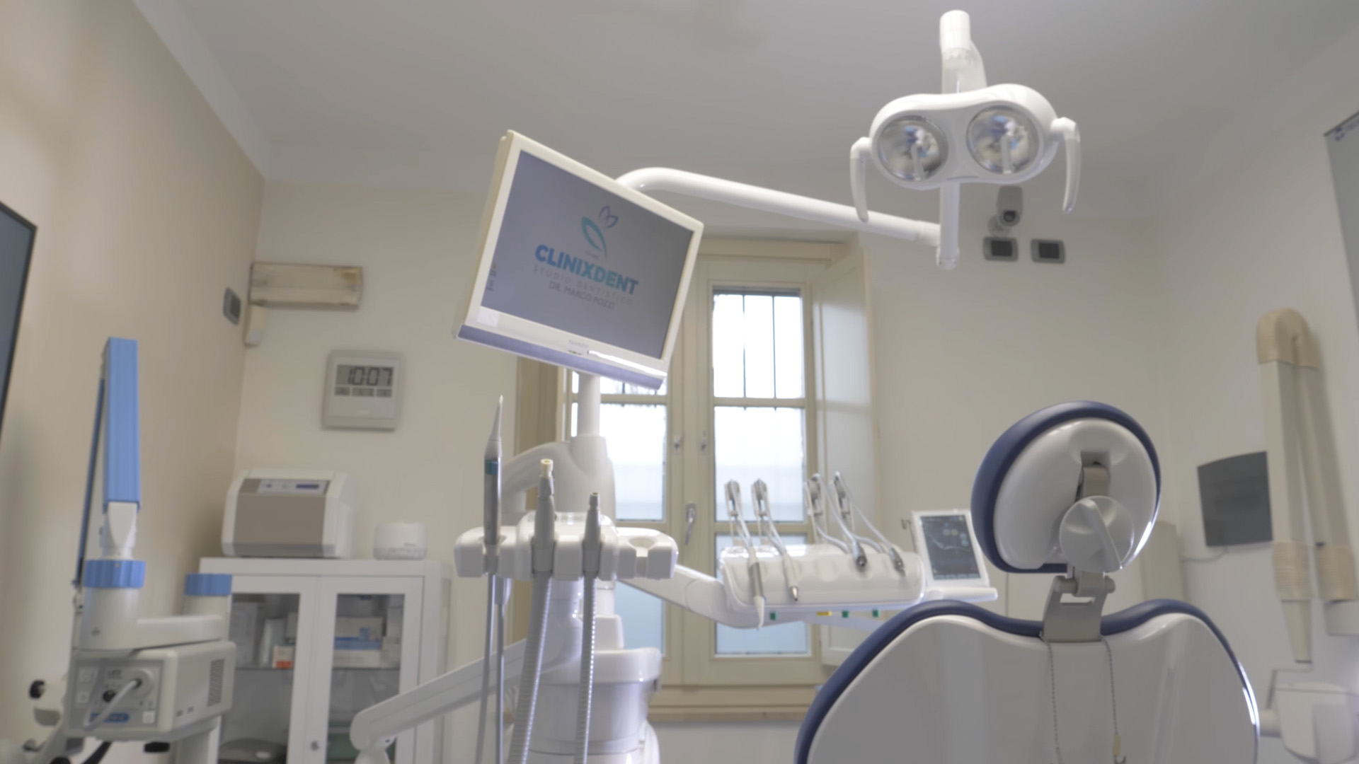 Sala operatoria con poltrona e monitor con logo Clinixdent